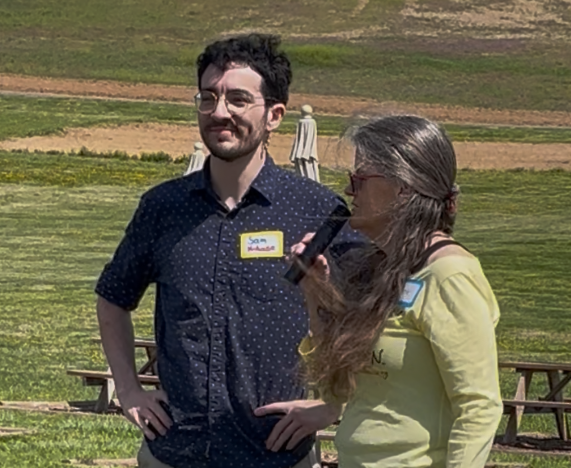Sam Newhouse speaking with a supporter at a community event